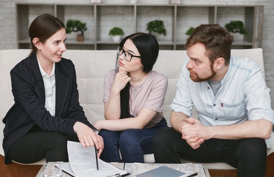 Dwoje profesjonalistów prowadzących rozmowę biznesową przy stole konferencyjnym.